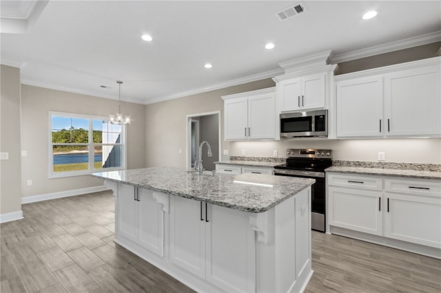 kitchen with white cabinets, a center island with sink, stainless steel appliances, and light stone countertops