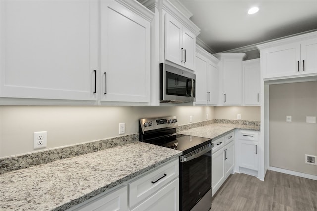 kitchen with light wood-type flooring, white cabinetry, stainless steel appliances, and light stone counters