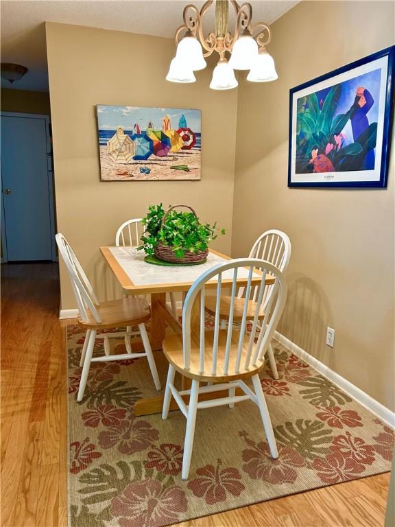 850 Mallery St Unit J-14, Saint Simons Island, GA 31522 - dining room featuring a chandelier, wood finished floors, and baseboards