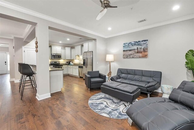 1108 Reserve Ln, Saint Simons Island, GA 31522 - living room with dark hardwood / wood-style floors, ceiling fan, and crown molding