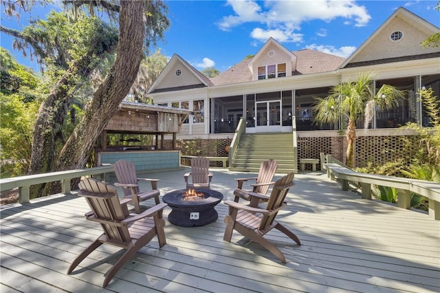 1232 Riverpoint Ln NE, Townsend, GA 31331 - deck featuring a fire pit, a sunroom, and stairway