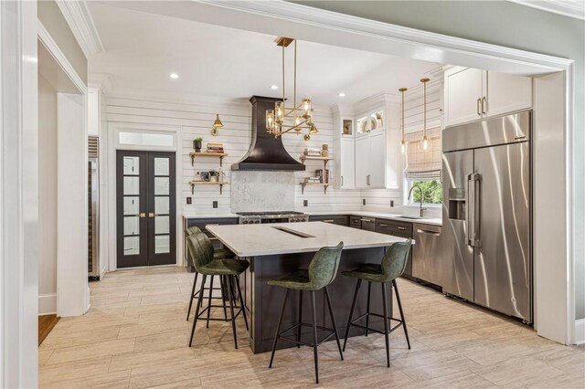 1232 Riverpoint Ln NE, Townsend, GA 31331 - kitchen with appliances with stainless steel finishes, custom range hood, a kitchen breakfast bar, light countertops, and decorative backsplash