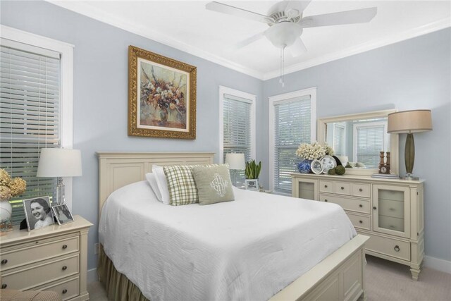 bedroom featuring baseboards, a ceiling fan, light colored carpet, and crown molding
