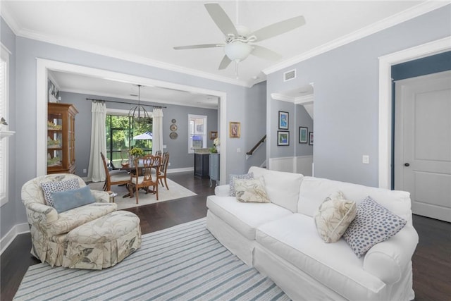 living room featuring dark wood finished floors, baseboards, ornamental molding, ceiling fan, and stairs