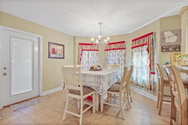 dining room featuring a chandelier, light tile patterned floors, and baseboards