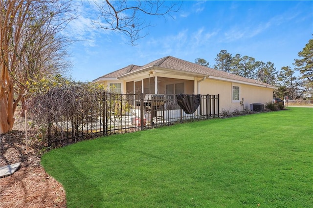 rear view of house featuring fence, central AC, stucco siding, a yard, and a patio area