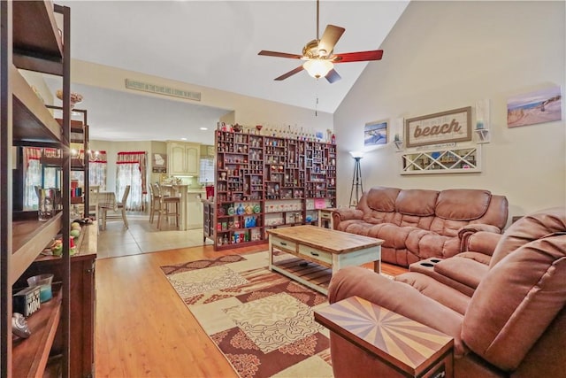 living room featuring high vaulted ceiling, light wood-type flooring, and ceiling fan