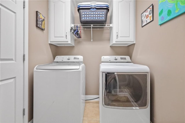 laundry area featuring tile patterned floors, cabinet space, and washer and clothes dryer