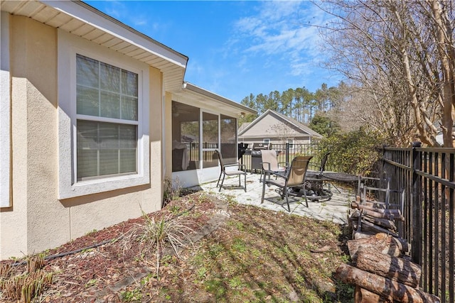 view of patio with a fenced backyard and a sunroom