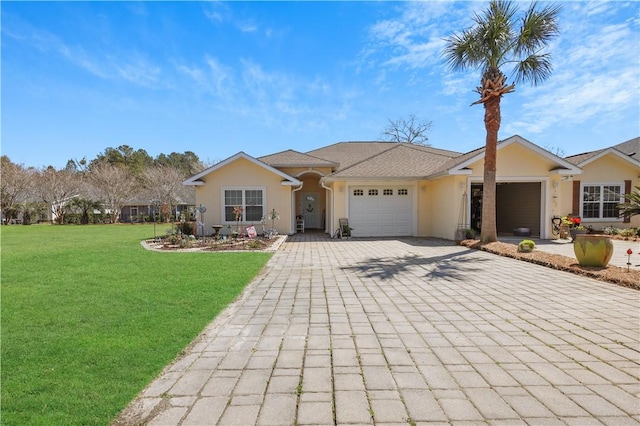 ranch-style home with a garage, decorative driveway, a front yard, and stucco siding