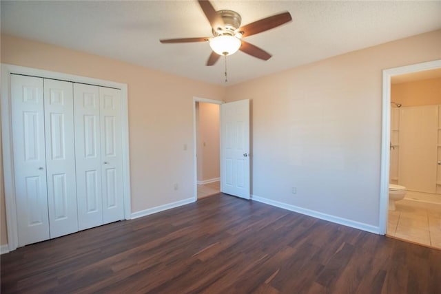 unfurnished bedroom with dark wood-type flooring, baseboards, and a closet