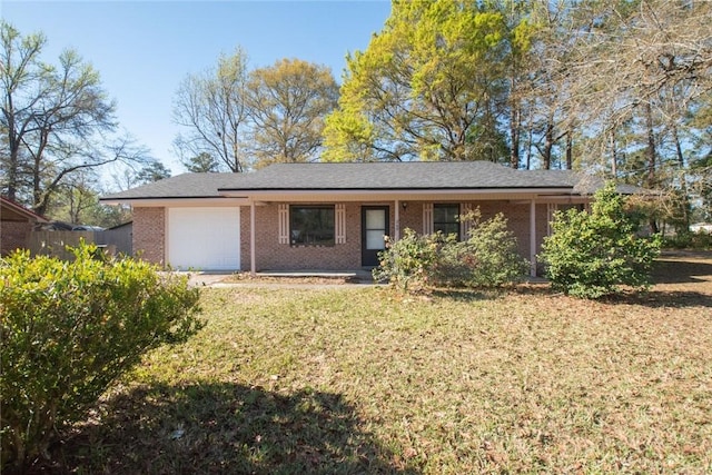 single story home with a front lawn, an attached garage, and brick siding