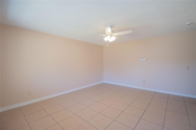 unfurnished room featuring a ceiling fan and baseboards