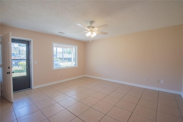 empty room featuring a ceiling fan, baseboards, visible vents, and a textured ceiling