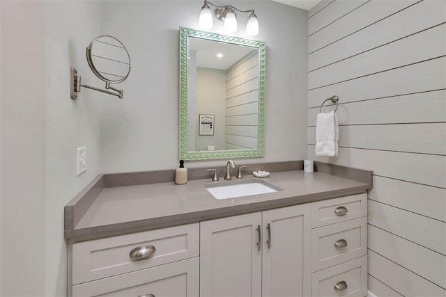 bathroom with vanity and wood walls