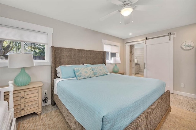 bedroom with ceiling fan and a barn door