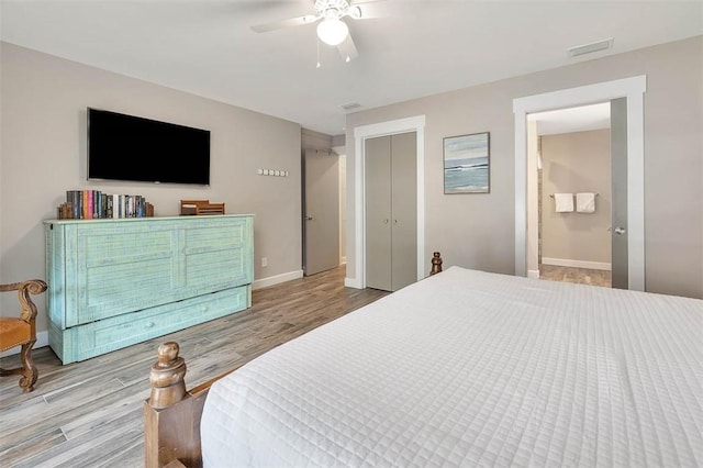 bedroom featuring light hardwood / wood-style floors, ceiling fan, and ensuite bathroom