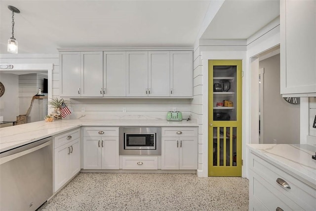 kitchen with light stone counters, appliances with stainless steel finishes, decorative light fixtures, and white cabinets