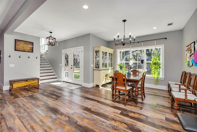 dining space with stairs, an inviting chandelier, and wood finished floors