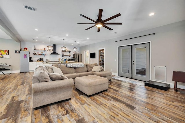 living area featuring visible vents, recessed lighting, a ceiling fan, and wood finished floors