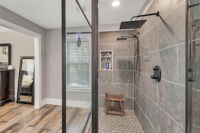 full bathroom with a shower stall, wood finished floors, and baseboards