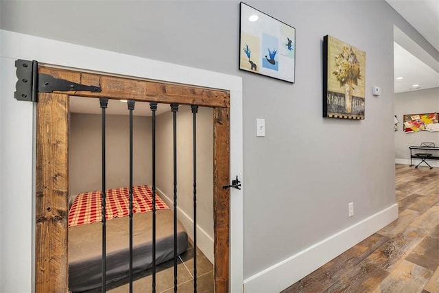 hall with baseboards and wood-type flooring