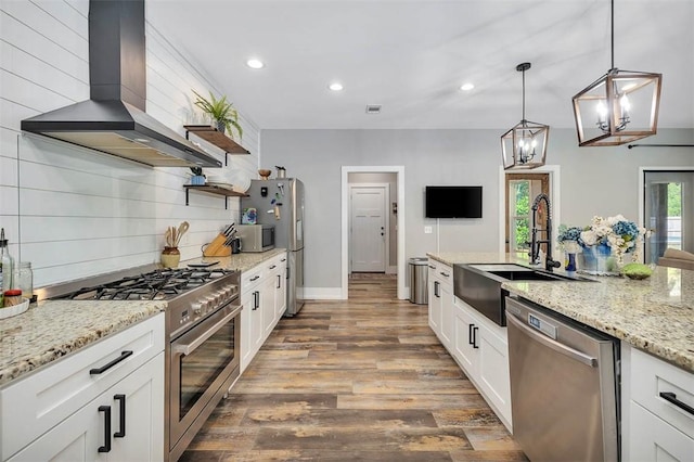 kitchen featuring a sink, open shelves, tasteful backsplash, appliances with stainless steel finishes, and wall chimney range hood