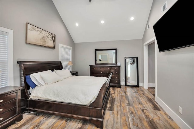 bedroom featuring visible vents, wood finished floors, recessed lighting, baseboards, and vaulted ceiling