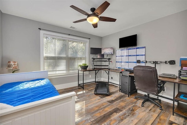 office with visible vents, wood-type flooring, baseboards, and a ceiling fan