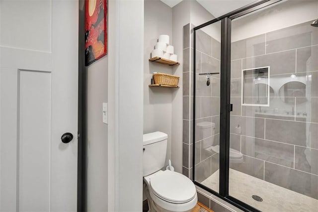 bathroom featuring toilet and a shower stall