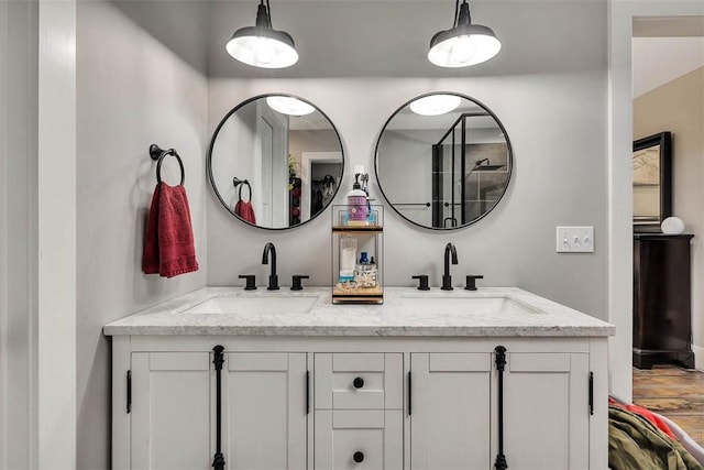 bathroom with double vanity, wood finished floors, and a sink