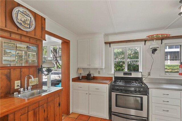 kitchen featuring gas stove, white cabinetry, sink, tasteful backsplash, and light tile patterned floors