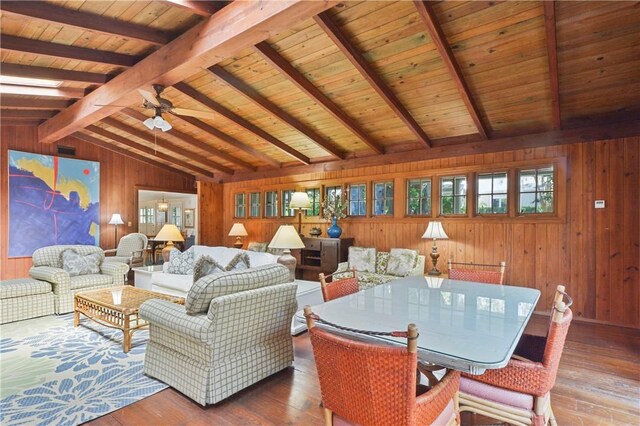 living room with ceiling fan, vaulted ceiling with beams, hardwood / wood-style floors, wooden walls, and wood ceiling