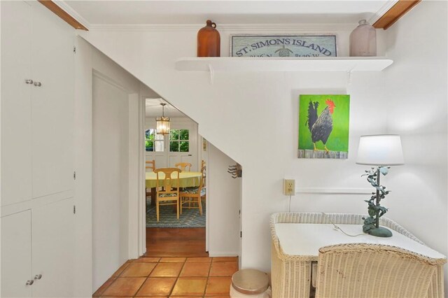 hallway with crown molding and light tile patterned floors