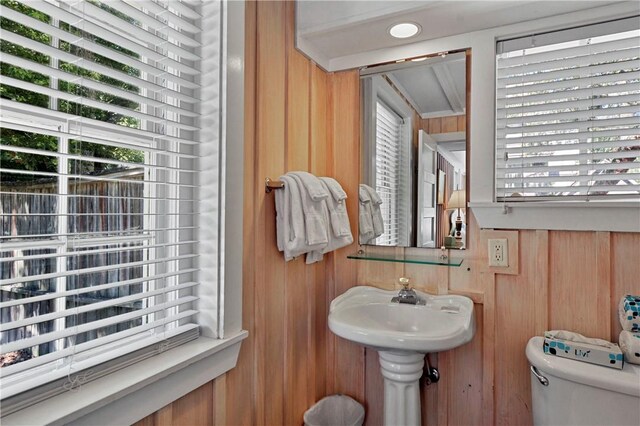 bathroom featuring toilet and wood walls