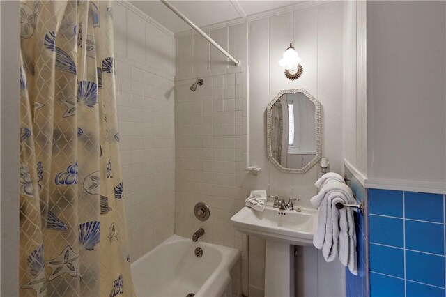 bathroom featuring shower / bath combo, crown molding, and tile walls