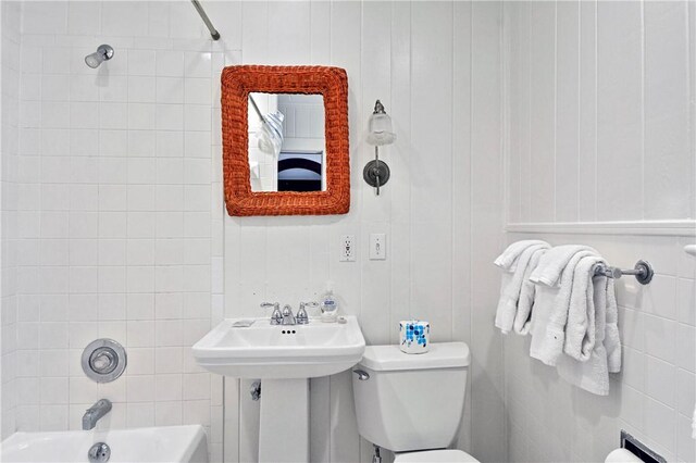 full bathroom featuring sink, toilet, and tiled shower / bath