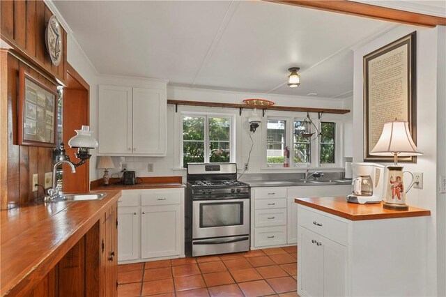 kitchen featuring gas range, white cabinetry, sink, and a wealth of natural light