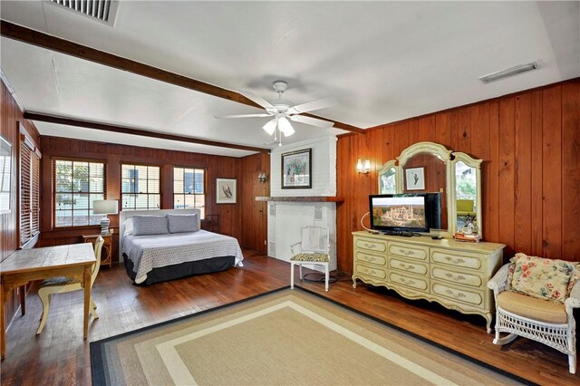 bedroom featuring hardwood / wood-style floors, ceiling fan, and wood walls