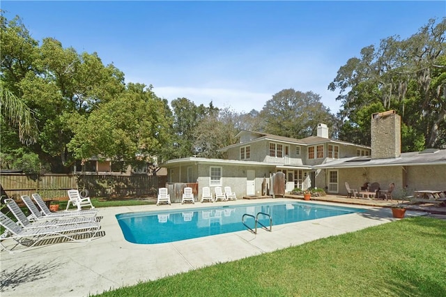 view of pool featuring a lawn and a patio