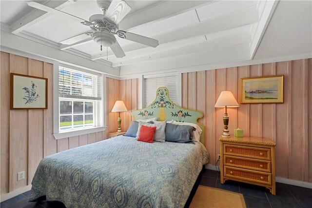 bedroom featuring beam ceiling, dark tile patterned floors, ceiling fan, and wood walls