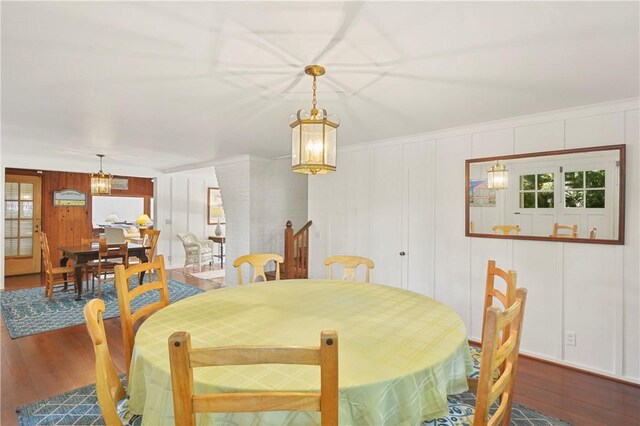 dining space featuring hardwood / wood-style floors and wooden walls