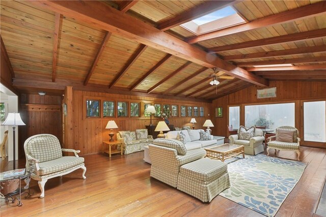 living room with wood ceiling, light wood-type flooring, wooden walls, and lofted ceiling with skylight