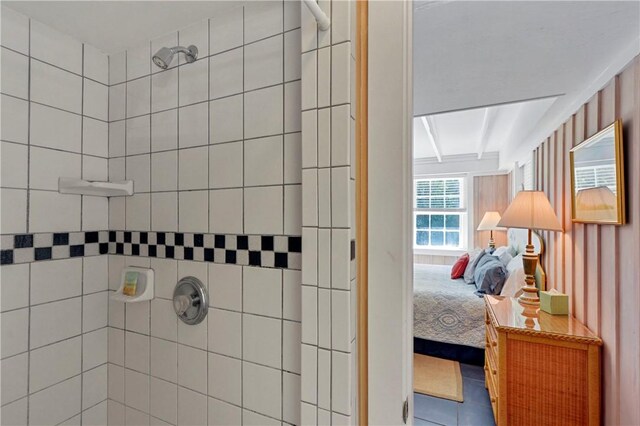 bathroom with tile patterned flooring and a tile shower