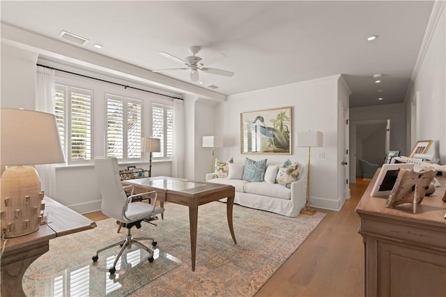 home office with crown molding, ceiling fan, and light hardwood / wood-style floors