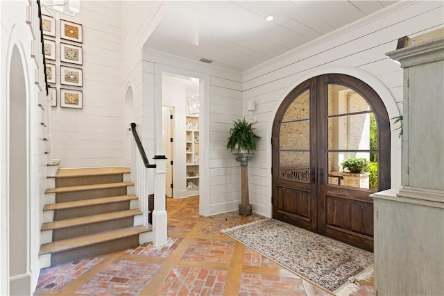 foyer entrance with french doors and wooden walls