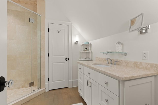 bathroom with vanity, an enclosed shower, vaulted ceiling, and hardwood / wood-style flooring