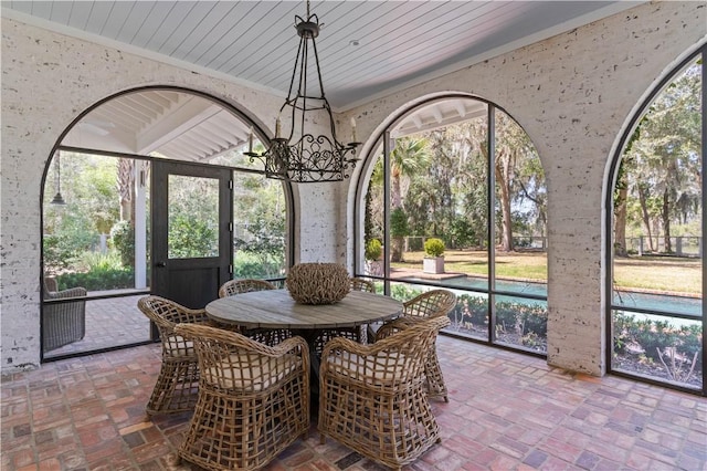 sunroom featuring wood ceiling and a notable chandelier