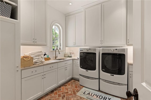 washroom featuring washer and dryer, cabinets, and sink