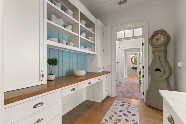 mudroom with dark hardwood / wood-style flooring and crown molding